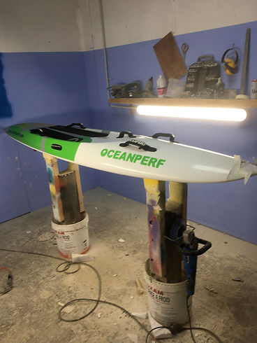 Board OceanPerf sur chevalets dans atelier de réparation surf